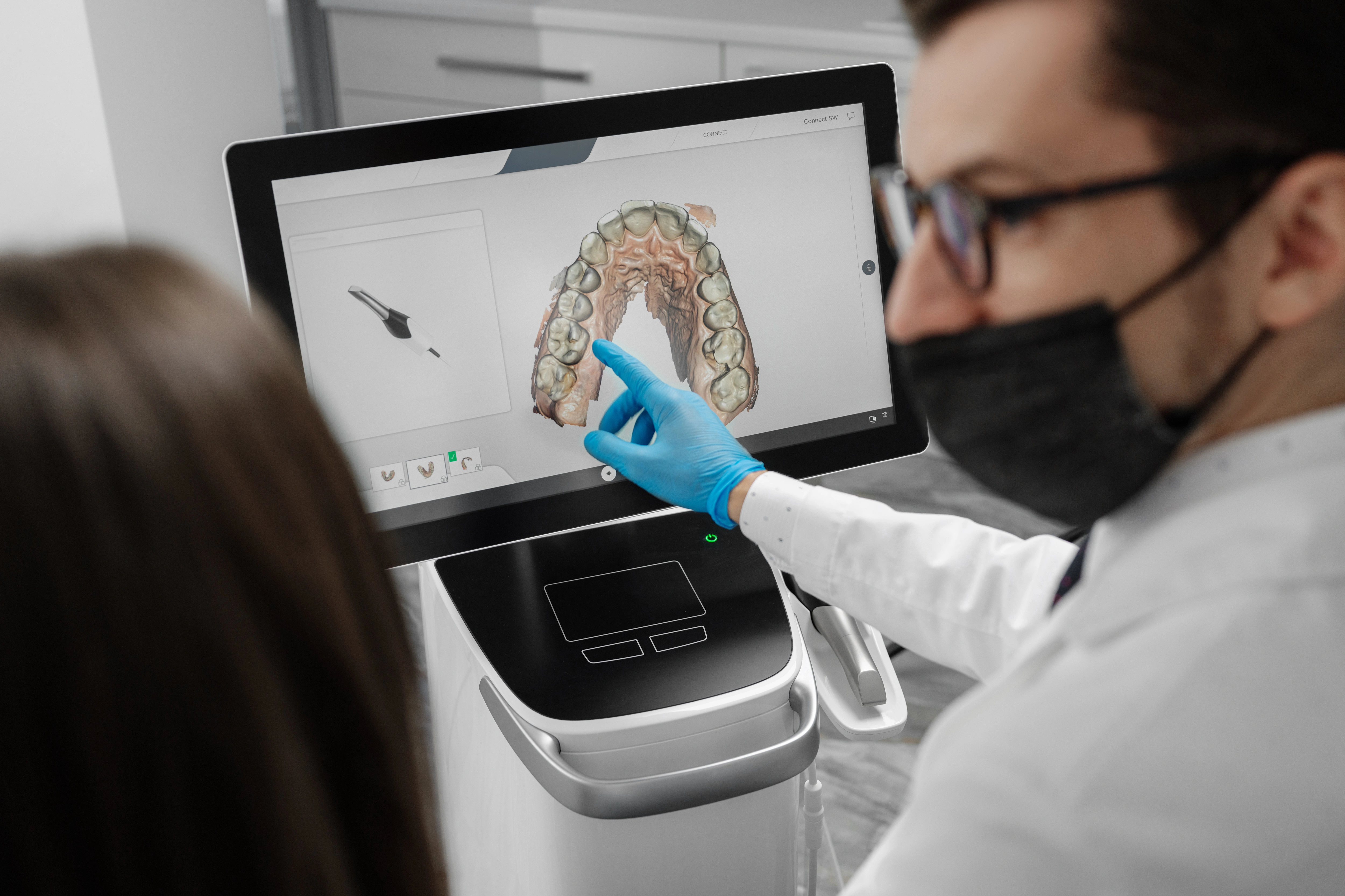 A dentist shows the results of a digital 3D scan of a patient’s teeth.